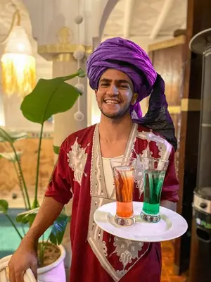 a man with a purple turban holding a tray of drinks at Riad Elli Marrakech in Marrakech