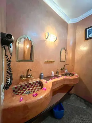 a bathroom with a large wooden tub with two sinks at Riad Elli Marrakech in Marrakech
