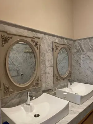a bathroom with two sinks and two mirrors at Villa DAAB OURIDA piscine chauffée Salle de sport in Marrakech