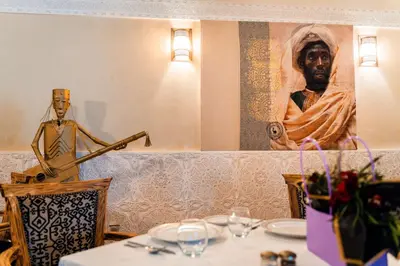 a table in a restaurant with a statue of a man at Ysalis Riad Restaurant & Spa in Marrakech