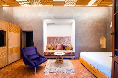 a bedroom with a bed and a couch and a chair at Ysalis Riad Restaurant & Spa in Marrakech