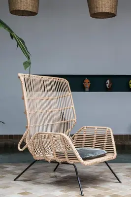 a rattan chair sitting next to a wall at Riad Danka in Marrakech