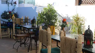 a group of tables and chairs with flowers on them at Dar Habache in Marrakech