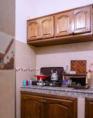 a kitchen with wooden cabinets and a stove top oven at Dar Habache in Marrakech