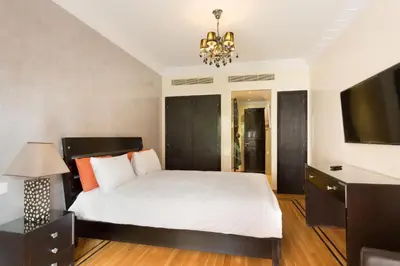 a bedroom with a large bed and a television at The Sapphire Apartment with Private Swimming Pool & Hot Tub - Hivernage Quarter - By Goldex Marrakech in Marrakech
