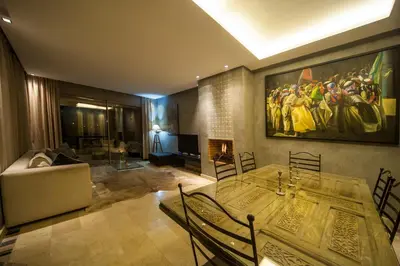a living room with a table and a painting on the wall at Villa Loubane in Marrakech