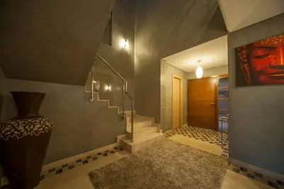 a hallway with a staircase and a vase on the wall at Villa Loubane in Marrakech