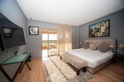 a bedroom with a bed and a desk and a television at Villa Loubane in Marrakech