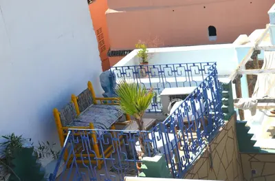 a balcony with chairs and a table and a plant at Riad Wink in Marrakech