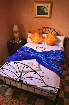 a bed with colorful sheets and pillows on it at Riad Wink in Marrakech
