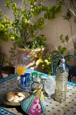 a table with a plate of food and a drink at Riad bleu du Sud in Marrakech