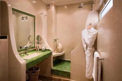 a bathroom with a green sink and a mirror at Riad Cocoon in Marrakech