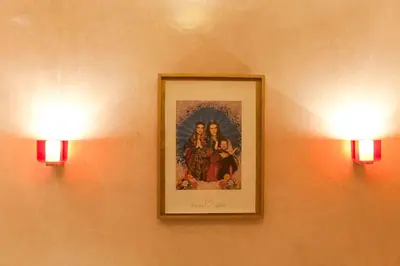 two lights on a wall with a picture of two women at Riad Cocoon in Marrakech
