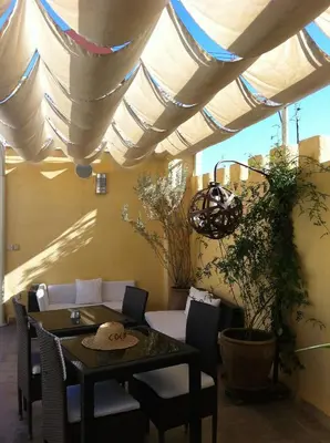 a patio with a table and chairs under awning at Riad Cocoon in Marrakech