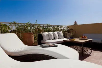 a patio with two white couches and a table at Riad Cocoon in Marrakech