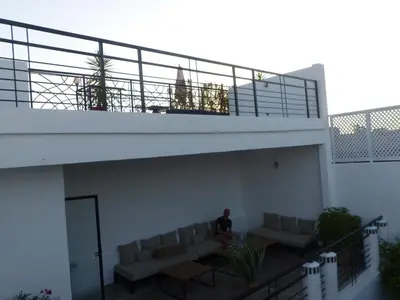 a man sitting on the balcony of a house at Riad Tchina in Marrakech