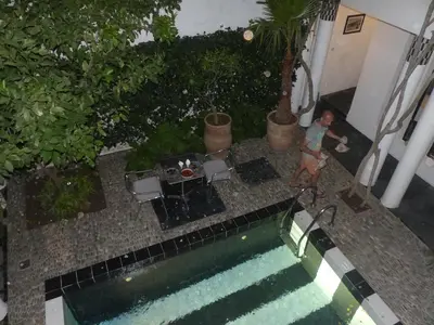 a person standing next to a swimming pool at Riad Tchina in Marrakech