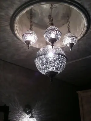 a bunch of chandeliers hanging from a ceiling at Riad Tchina in Marrakech
