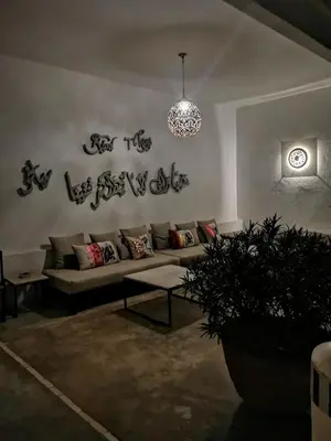 a living room with a couch and a clock on the wall at Riad Tchina in Marrakech