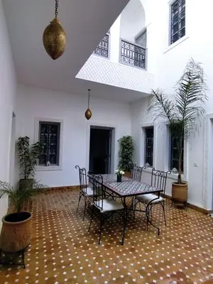 a dining room with a table and chairs in a house at Riad El Arco ROOFTOP POOL & Spa in Marrakech