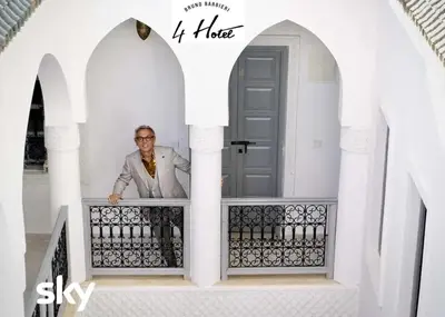 a man standing on the balcony of a house at Riad El Arco ROOFTOP POOL & Spa in Marrakech