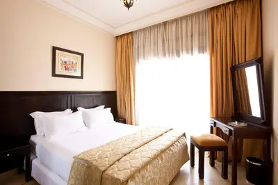 a hotel room with a bed and a window at Mogador Menzah Appart Hôtel in Marrakech