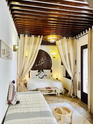 a bedroom with a large bed and a large window at Riad La Porte Rouge By La Siredrah in Marrakech