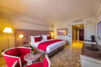 a bedroom with a bed and a living room at Grand Mogador Menara & Spa in Marrakech