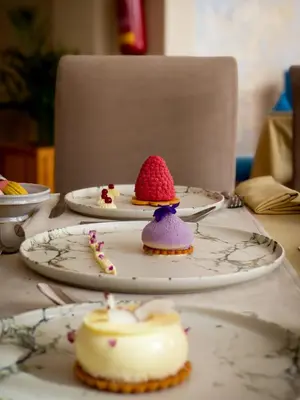 a table with three plates with cakes on them at Grand Mogador Menara & Spa in Marrakech