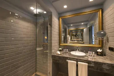 a bathroom with a sink and a shower and a mirror at Grand Mogador Menara & Spa in Marrakech