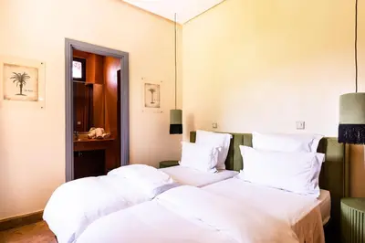 two beds in a room with white sheets and pillows at Villa de Luxe avec Piscine Privée et Golf in Marrakech