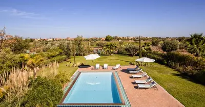 an overhead view of a swimming pool with chairs and umbrellas at Villa de Luxe avec Piscine Privée et Golf in Marrakech