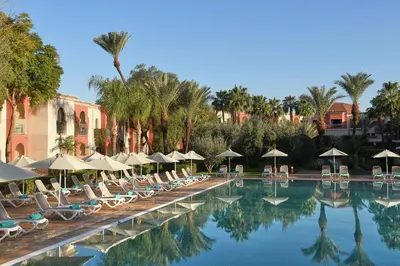 a swimming pool with lounge chairs and umbrellas at Iberostar Waves Club Palmeraie Marrakech All Inclusive in Marrakech