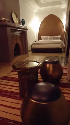 a bedroom with a bed and a fireplace in a room at Riad Tahar Oasis in Marrakech