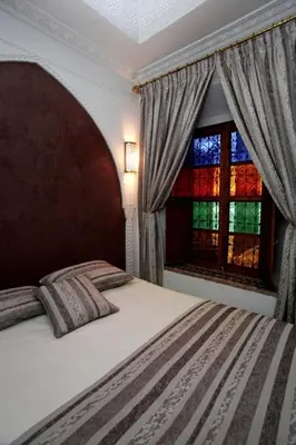 a bedroom with a large bed and a window at Riad Tahar Oasis in Marrakech