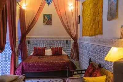 a bedroom with a bed in a room with curtains at Riad Sidi Omar in Marrakech