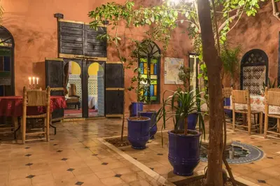 a restaurant with a table and plants in a room at Riad Sidi Omar in Marrakech