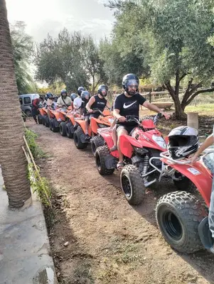 a group of people riding on atvs on a dirt road at Riad Sidi Omar in Marrakech