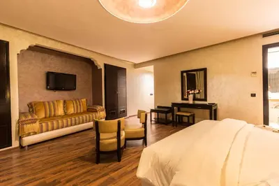 a hotel room with a bed and a couch at Hotel Almas in Marrakech