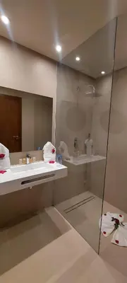 a bathroom with a shower and a sink and a mirror at Hotel Almas in Marrakech