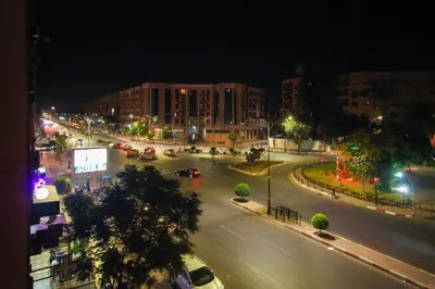 a city street at night with cars on the road at Hotel El Hadna By HMS in Marrakech