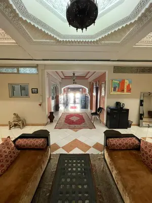 a living room with two couches and a ceiling at Hôtel Narjisse in Marrakech