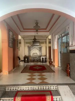 a lobby with an archway and a living room at Hôtel Narjisse in Marrakech