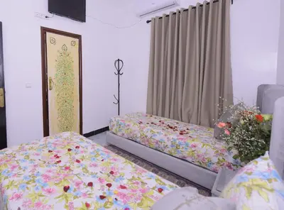 two beds in a room with flowers on them at Hotel Riad Fantasia in Marrakech