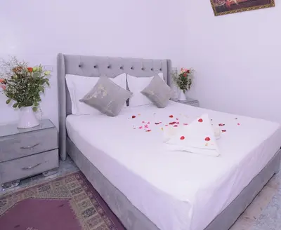 a bedroom with a white bed with flowers on it at Hotel Riad Fantasia in Marrakech