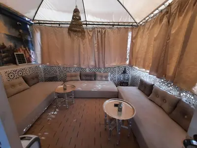 a living room with a large couch and two tables at Riad 1001 couleurs in Marrakech