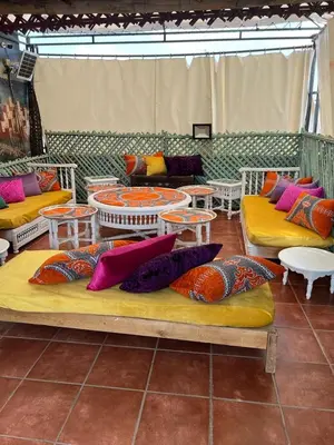 a room with couches and tables and colorful pillows at Riad 1001 couleurs in Marrakech