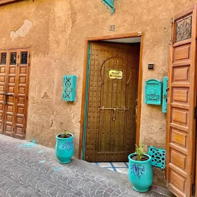 two blue vases sitting in front of a door at Riad 1001 couleurs in Marrakech