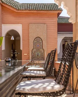 a group of chairs sitting in front of a wall with aificantificantificantificant at Indian Palace in Marrakech