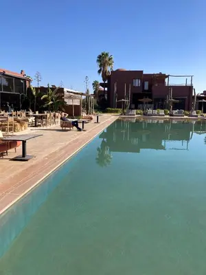 a large swimming pool with blue water in a resort at Fellah Hotel in Marrakech